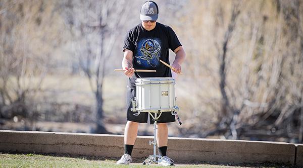 Student playing drums outside
